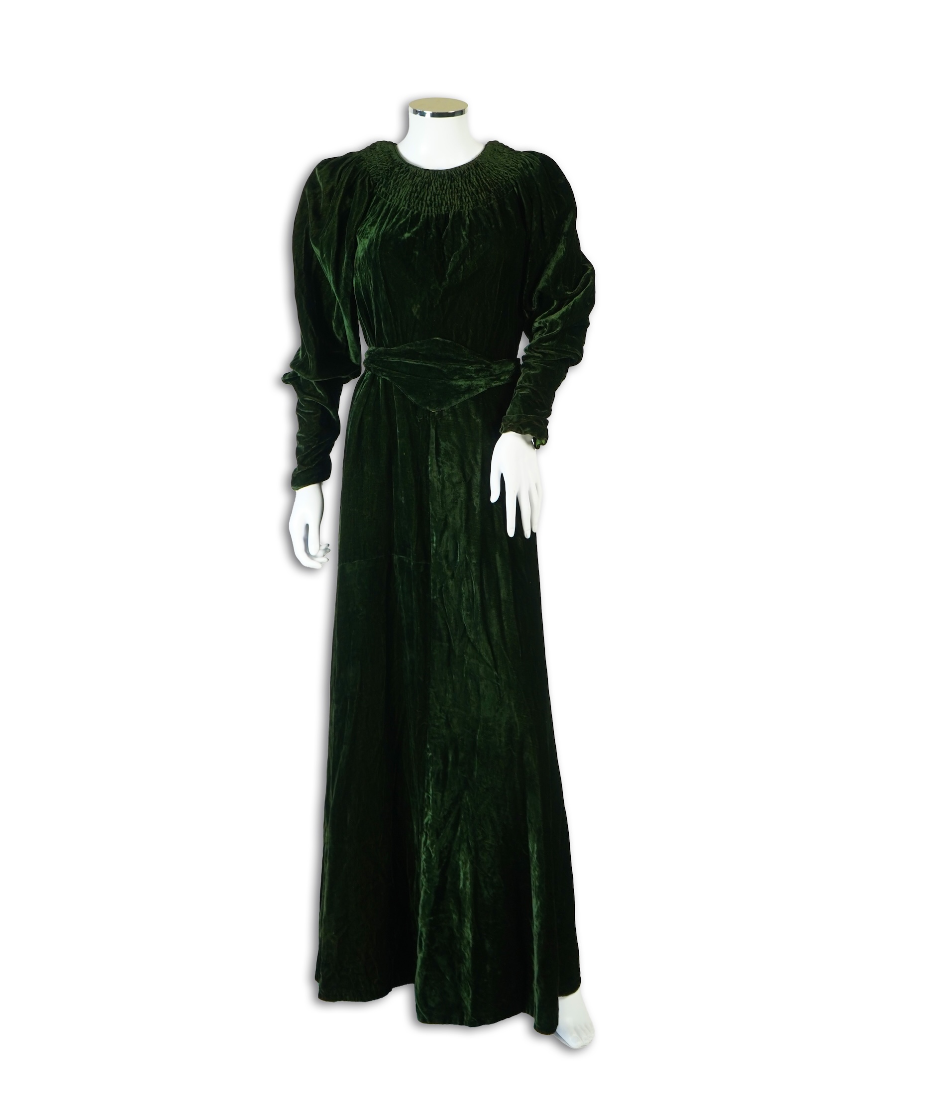 A flesh coloured 1930s lace evening dress and matching jacket together with a bottle green velvet evening dress and buckle belt and an unusual green shot silk pleated under skirt. Lace dress bust 32 inches. 156cm long. C